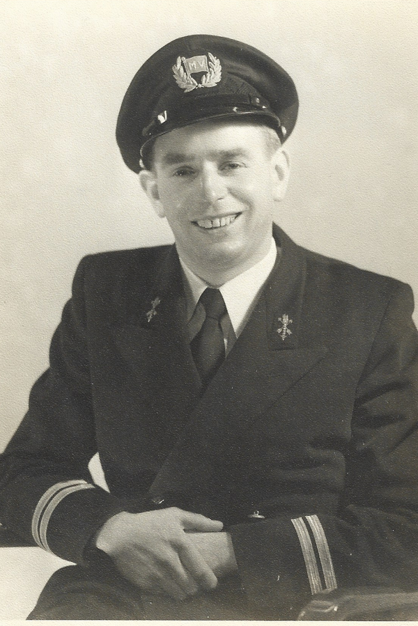 Zwart-witportret van Albert Heldoorn als 1e machinist op de ms Tiba, met officierspet, 'MV'-embleem en caduceus-insignes.